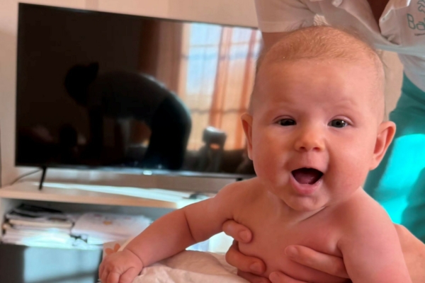 Baby beim Babyschwimmen zu Hause in der Badewanne